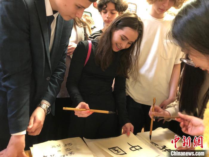 4月21日，莫斯科國(guó)立語言大學(xué)孔子學(xué)院附屬中學(xué)舉辦“國(guó)際中文日”活動(dòng)，學(xué)生們學(xué)寫漢字?！∧箍茋?guó)立語言大學(xué)孔子學(xué)院 供圖