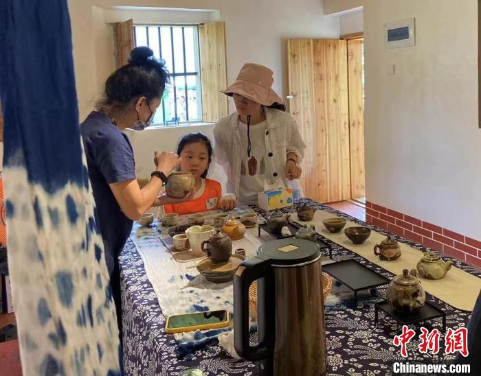 圖為：游客正在咨詢臺灣柴燒作品?！∪~秋云 攝