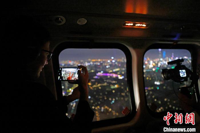 6月3日晚，游客乘坐上海新空直升機(jī)有限公司直升機(jī)開(kāi)啟鳥(niǎo)瞰黃浦江空中圓夢(mèng)之旅，并用手機(jī)拍攝城市夜景?！∫罅⑶?攝