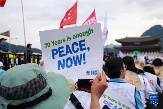7月22日，在韓國首爾，人們手舉標(biāo)語參與反戰(zhàn)游行。新華社發(fā)（楊暢 攝）