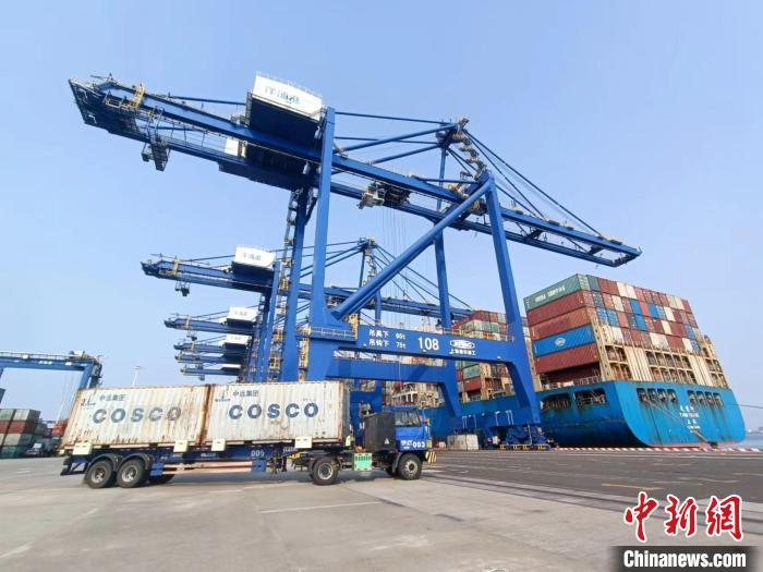 圖為海南洋浦國際集裝箱碼頭，卡車將集裝箱從后方堆場(chǎng)運(yùn)往碼頭裝卸區(qū)。　張?jiān)潞?攝
