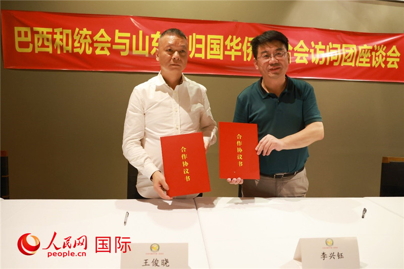 中國(guó)僑聯(lián)副主席、山東省僑聯(lián)主席李興鈺（右）與巴西和統(tǒng)會(huì)會(huì)長(zhǎng)王俊曉簽署合作協(xié)議書。人民網(wǎng)記者 陳海琪攝