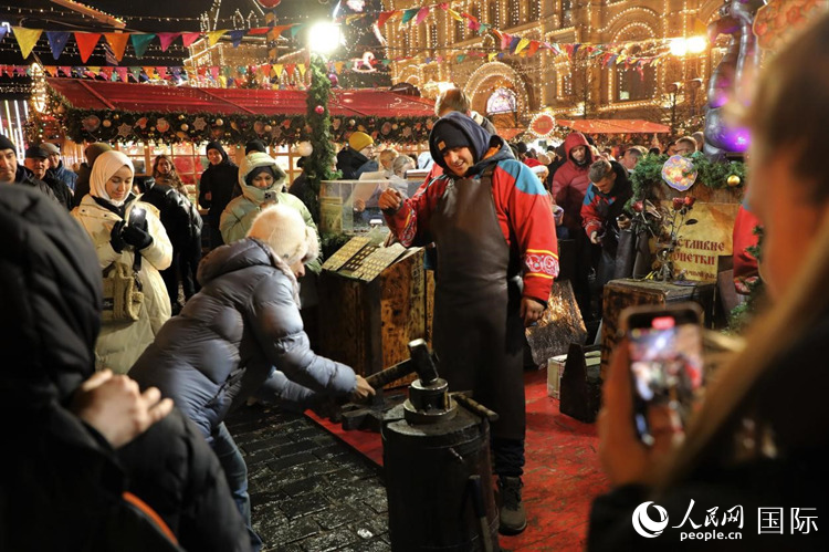 游客在新年集市上體驗(yàn)制作紀(jì)念幣。人民網(wǎng)記者 隋鑫攝