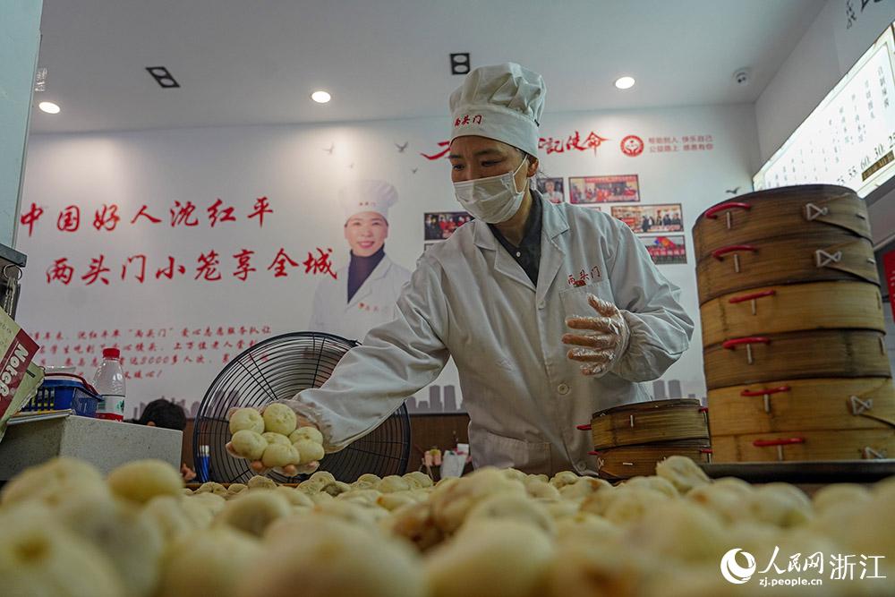 3月31日，在浙江省嵊州市甘霖鎮(zhèn)，嵊州小吃從業(yè)者沈紅平把蒸熟的小籠包晾涼，打包冷藏售賣。人民網(wǎng) 章勇濤攝
