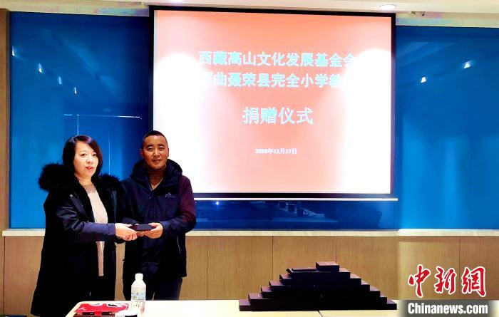 圖為西藏高山文化發(fā)展基金會理事長溫麗向聶榮縣完全小學負責人捐助儀器?！∮谫e 攝