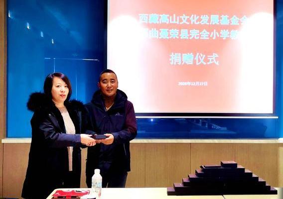 圖為西藏高山文化發(fā)展基金會(huì)理事長(zhǎng)溫麗向聶榮縣完全小學(xué)負(fù)責(zé)人捐助儀器?！∮谫e 攝