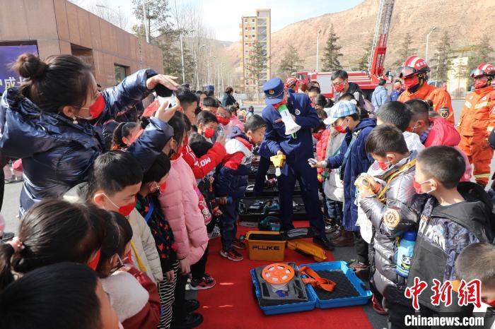 圖為小朋友們聽消防員講解消防器材。　楊龍建 攝