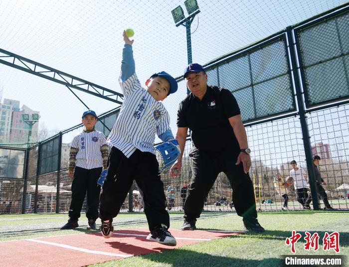 圖為來自臺(tái)灣的棒球教練劉興鴻(右)指導(dǎo)小棒球手?jǐn)S球技術(shù)?！●R銘言 攝