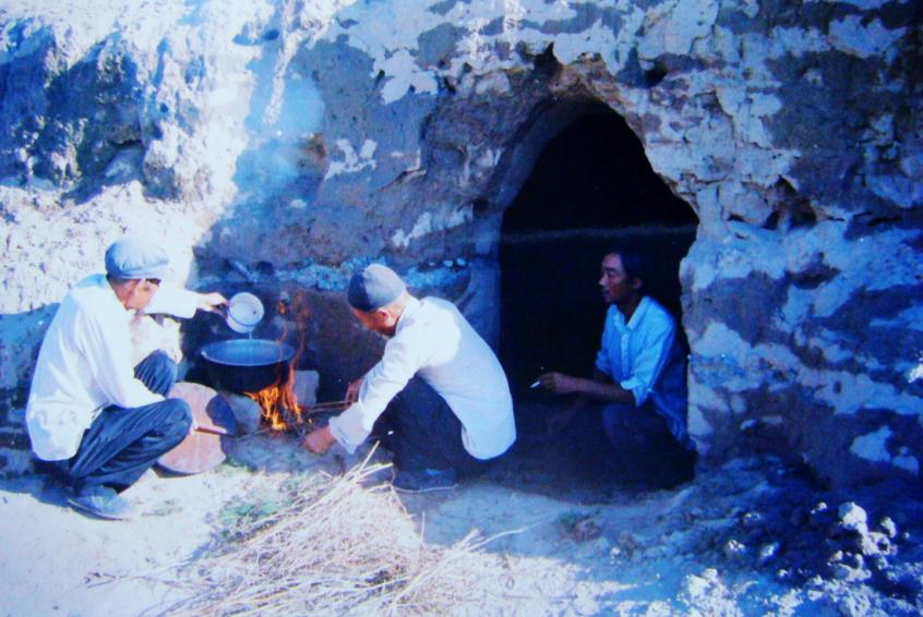 1983年，“六老漢”一代治沙人在“地窩子”生活做飯。新華社發(fā)（八步沙林場供圖）