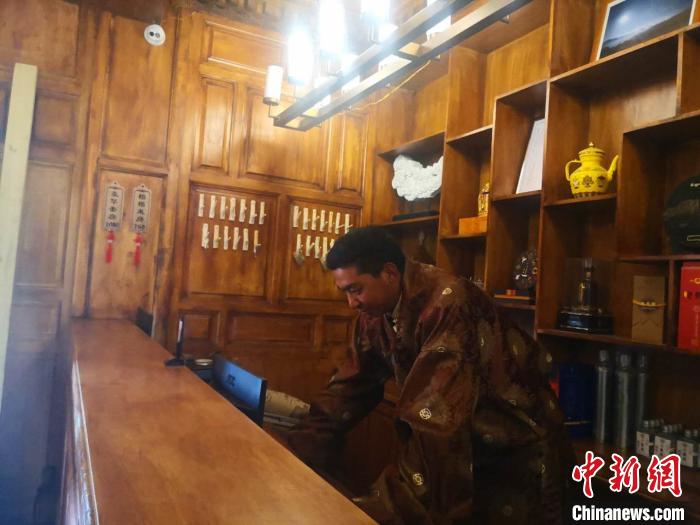 圖為桑杰才讓用電腦處理財務(wù)?！∈缝o靜 攝