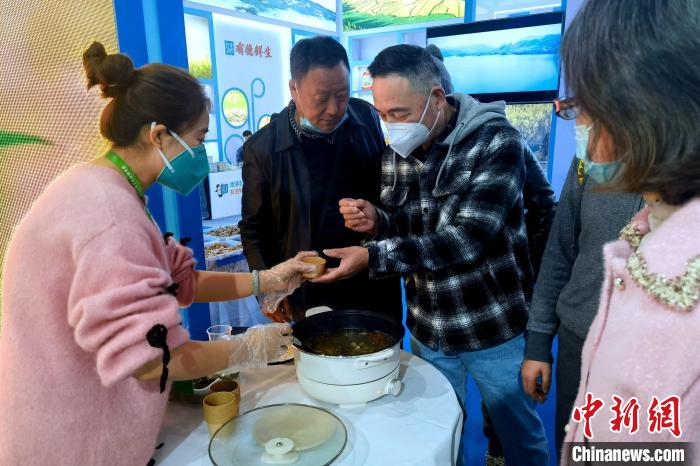 圖為杭州市民品嘗茶卡羊肉?！±铍h 攝