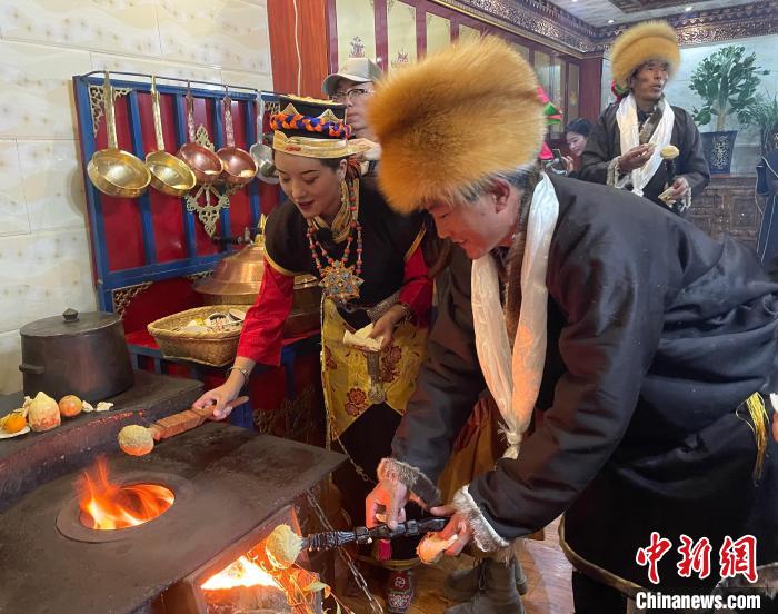 圖為人們在火上烤節(jié)日美食“結(jié)達(dá)”。　冉文娟 攝