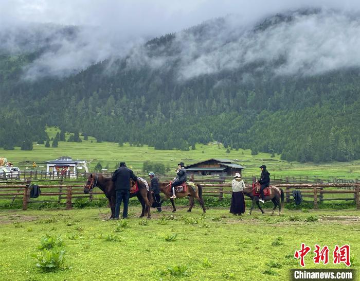 6月10日，游客在魯朗小鎮(zhèn)高山牧場(chǎng)景區(qū)體驗(yàn)騎馬?！∪轿木?攝