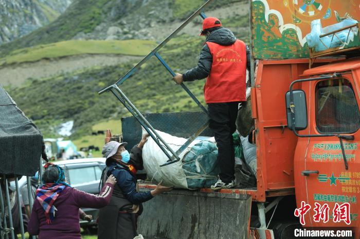 圖為工作人員幫助牧民們卸家具?！÷蹇?攝