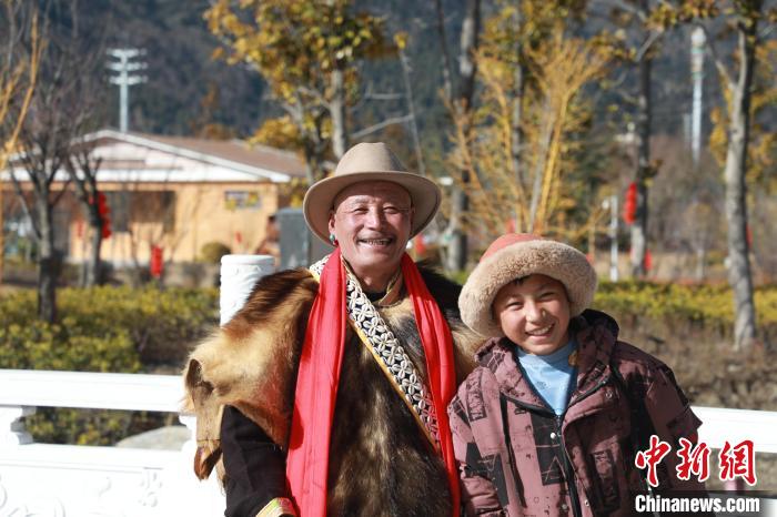 圖為林芝市巴宜區(qū)布久鄉(xiāng)仲果村村民桑杰與孫子一起參加藏歷新年活動(dòng)?！埩?攝