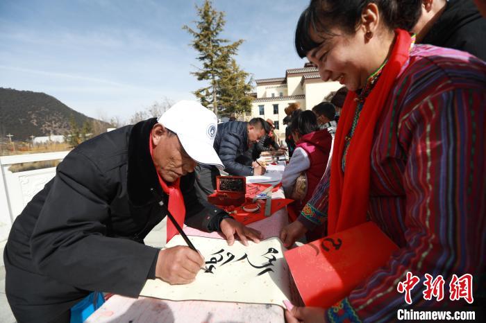 圖為林芝市文聯(lián)書(shū)法家協(xié)會(huì)會(huì)員向民眾贈(zèng)送藏文書(shū)法作品?！埩?攝