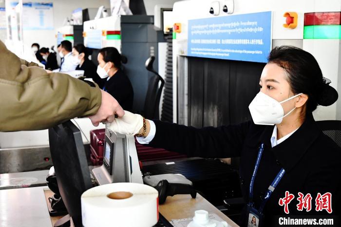 圖為機(jī)場工作人員為旅客辦理行李托運(yùn)。　周航 攝