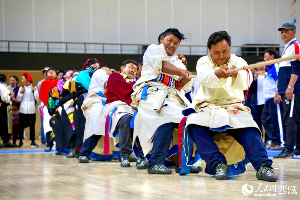 身著民族服裝的農(nóng)牧民選手在拔河比賽現(xiàn)場。